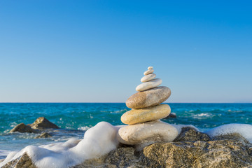 Stones pyramid on sand symbolizing zen, harmony, balance. Ocean