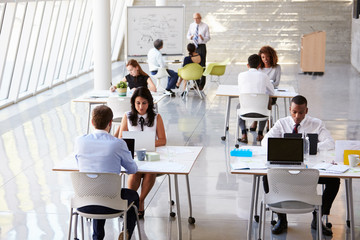 Overhead View Of Businesspeople Working At Desks In Office
