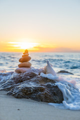 Stones pyramid on sand symbolizing zen, harmony, balance. Ocean