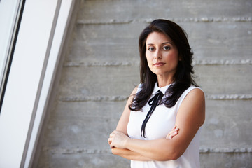 Portrait Of Businesswoman Standing Against Wall In Office