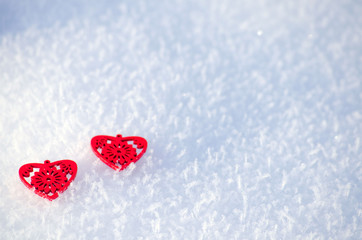 Decorative red hearts on a background of snow