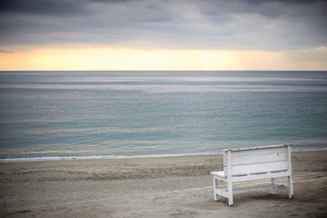 Obraz na płótnie Canvas 夕暮れの海岸とベンチ