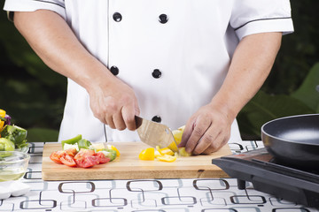 Chef cutting yellow bell pepper