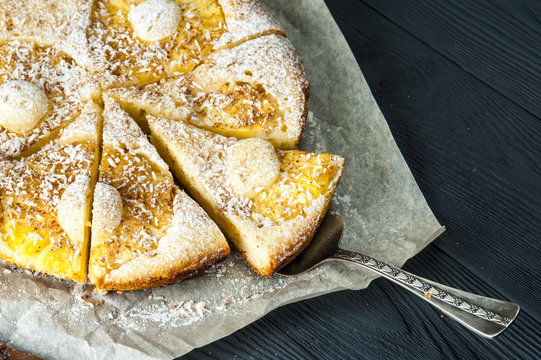 Cutted pineapple pie on baking paper with scapula