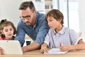 Teacher with students in class using digital tablet