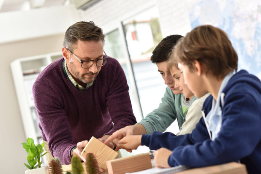School teacher in science class with pupils - Powered by Adobe
