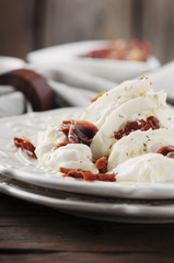 Traditional italian antipasto with burrata and dry tomato