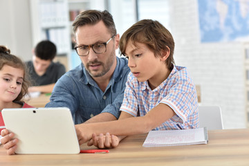 Teacher with students in class using digital tablet