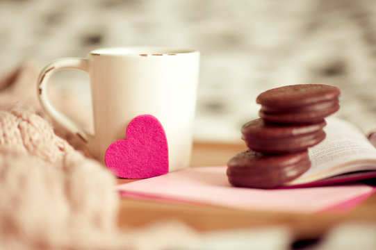Fototapeta Valentines day breakfast. Cup of coffee with chocolate cookies, book, letters staying on wooden tray in bedroom. Resting. Celebrating february 14th.