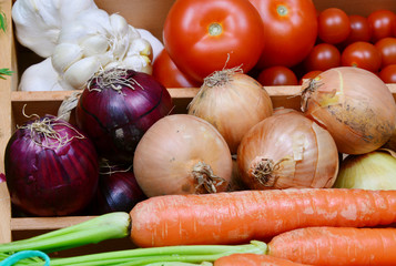 Carrots,onion,red onion,garlic,tomatoes,potatoes.
a lot of colorful vegetable in the kitchen.