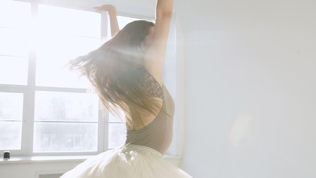 silhouette of ballerina in classical tutu in the white studio.
