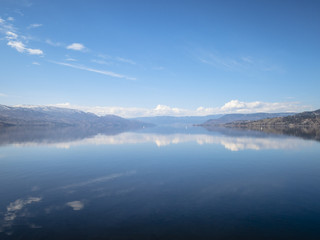 Fototapeta na wymiar Reflections on a Still Lake in Springtime
