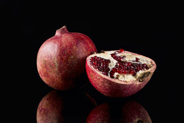 Ripe pomegranate on black background
