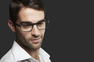 Young man in spectacles looking away
