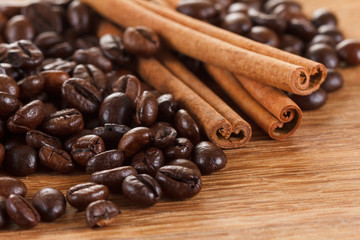 Coffee beans with cinnamon and anise on wooden table
