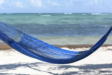 Hammock Overlooking the Caribbean Sea:  A bright blue hammock on the beach at Soliman Bay near Tulum, Mexico