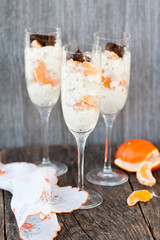 Raw vegan dessert in a glass with cashew nuts and oranges
