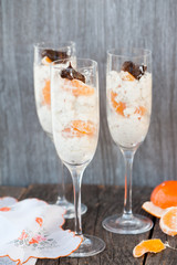 Raw vegan dessert in a glass with cashew nuts and oranges