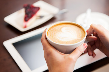 close up of hands with coffee, tablet pc and cake