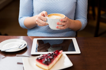close up of hands with coffee, tablet pc and cake