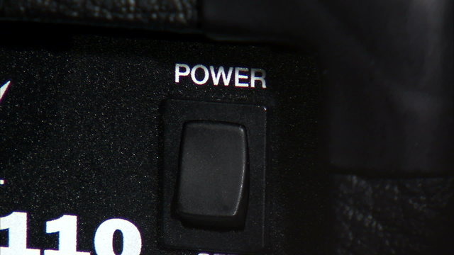 Close up of guitar amp power switch being turned on and off.