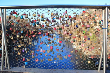Fototapeta premium Verlobte hängen Schlösser an das Geländer einer Brücker (Valentinstag)