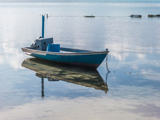 Fishing boat in the water with reflection
