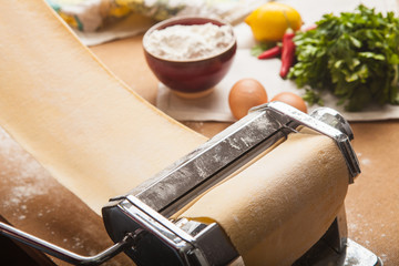The fresh pasta and  machine on kitchen table