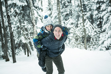Fototapeta na wymiar Father and son enjoying snow at daytime