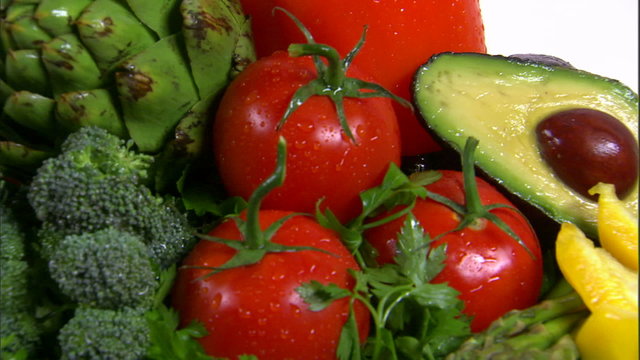 Close shot of an assortment of vegetables rotating on a white screen.