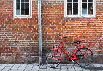 Fototapeta na wymiar Red bicycle near red wall. Copenhagen, Denmark