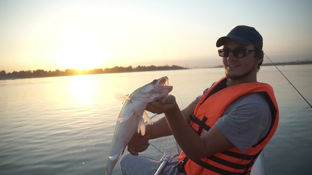 fisherman man holding a big fish pike.