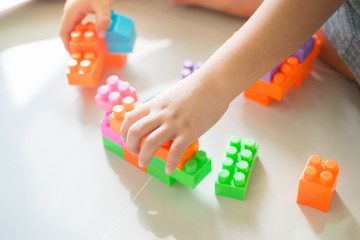Boy hands playing with colorful plastic blocks
