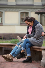 Happy couple surfing the Internet in the city