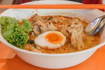 Noodles in Thai spicy tom yum soup with egg and Shrimp Wonton