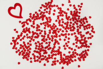 single felt heart with cinnamon heart candies on a rough textured painters canvas background