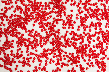 lots of red cinnamon heart candy on a rough textured painters canvas background