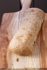 Pastry ciabatta on a wooden board on a black background. Italian pastries. gluten-free. basis for sandwiches