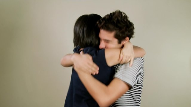 Cheerful couple exulting, hugging and kissing in studio