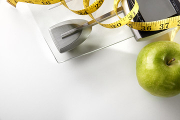Scale with apple and tape measure horizontal composition top