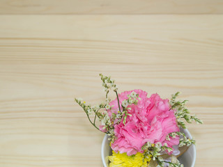small bouquet in mug , wooden background, top view