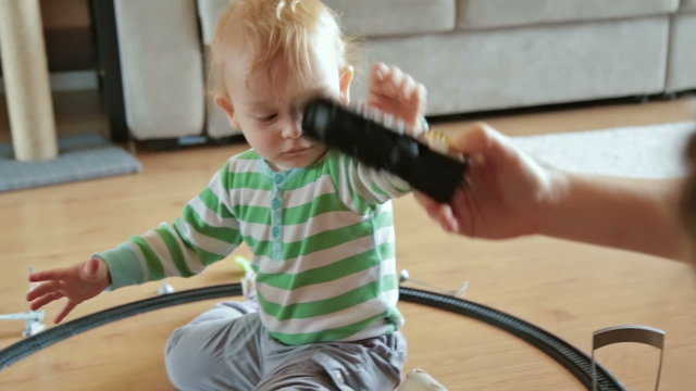 Little boy with mother playing with toy train