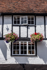 Fototapeta na wymiar Quaint old English pub with Tudor architecture and flowers in hanging baskets