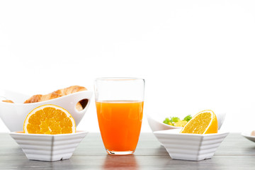 Gesundes Frühstück. Zwei halbe Orangen in eckigen Schalen und ein Glas Orangensaft. Im...