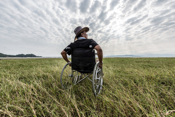 Man on a wheelchair relaxing in a park