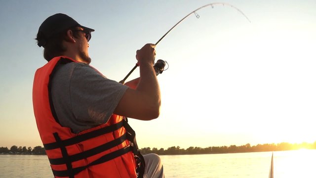 male fisherman actively fishing. 