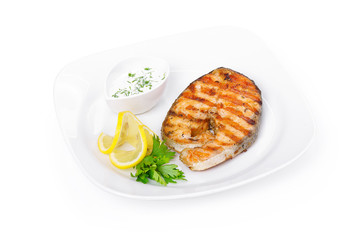 Grilled salmon steak with sauce and lemon