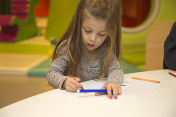 Little girl drawing in the playroom