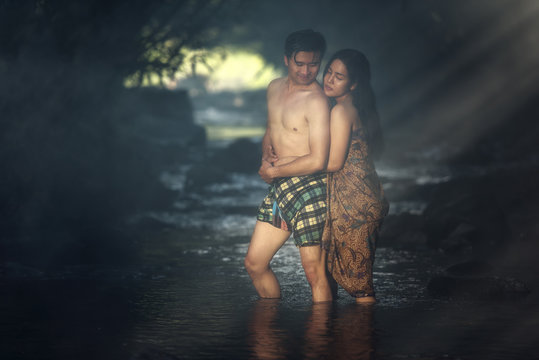 Asian couple bathing at cascade