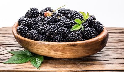 Blackberries in the wooden bowl. White background.